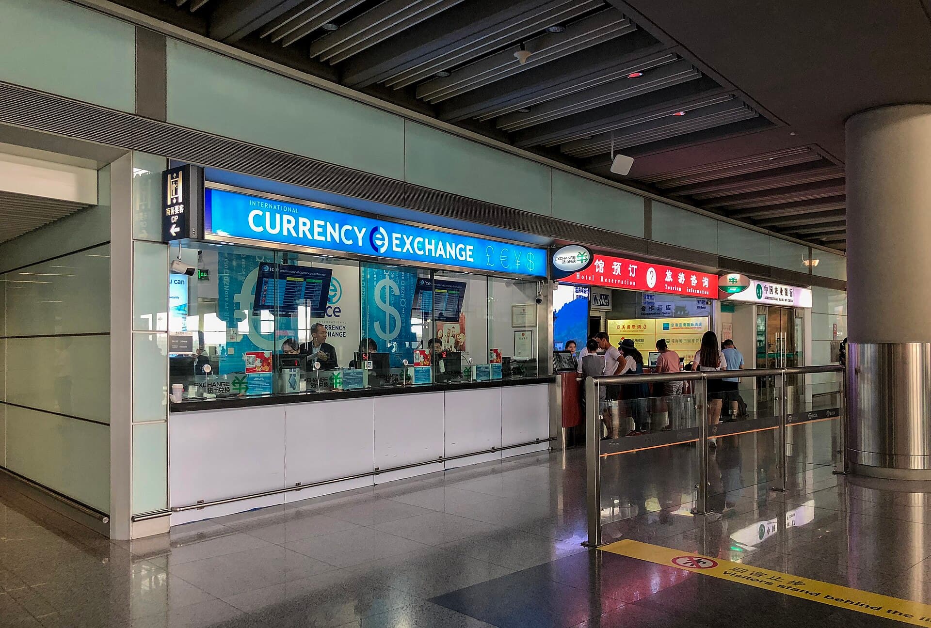 A row of currency exchange counters in an airport international arrivals hall
